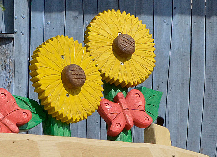 Holzbank rustikal mit figürlichen Sonnenblumen