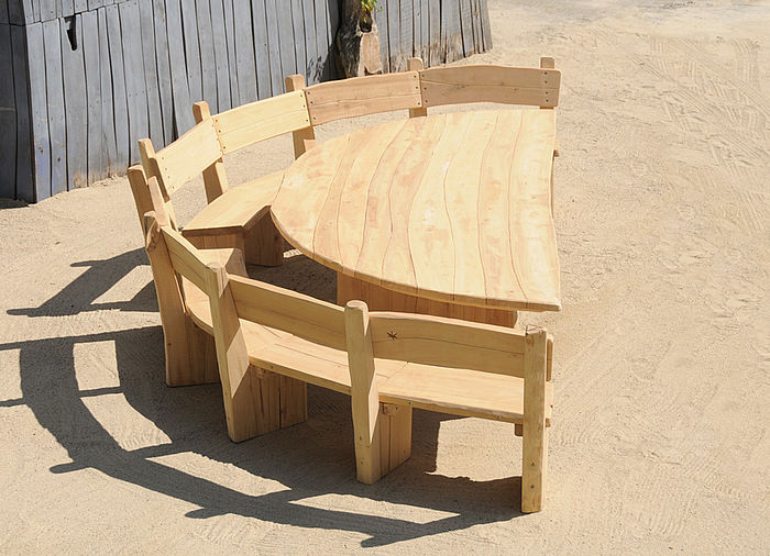 Semi-circular bench with table made of wood